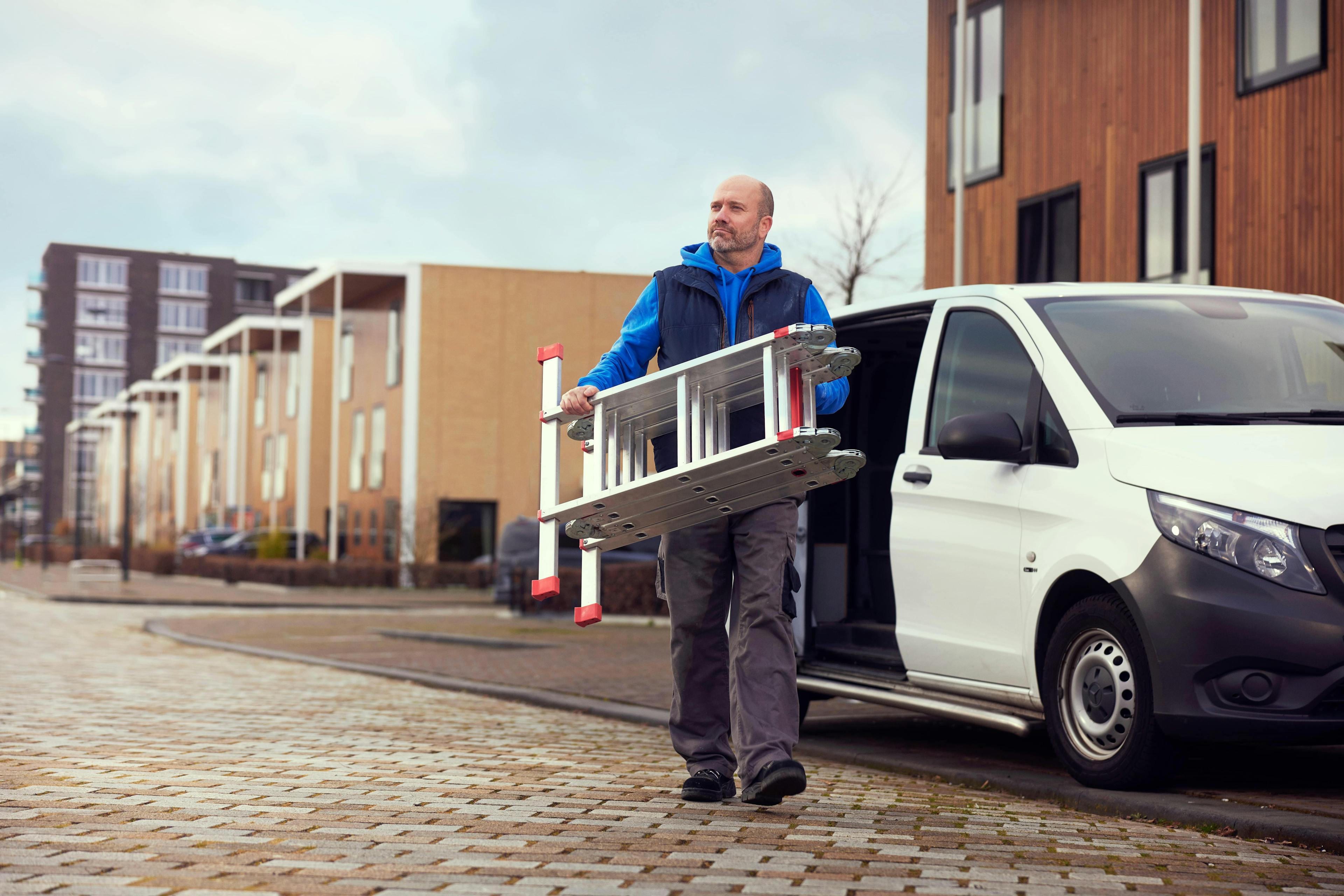 Man met ladder loopt weg van bestelbus